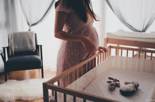 femme enceinte devant un lit bébé
