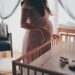 femme enceinte devant un lit bébé