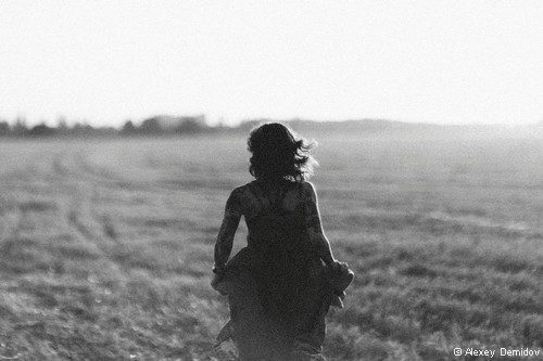 femme de dos marche dans un champ
