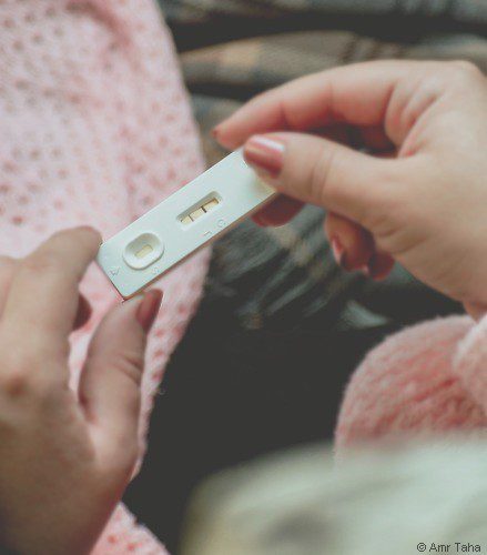 femme tient dans ses mains un test de grossesse positif