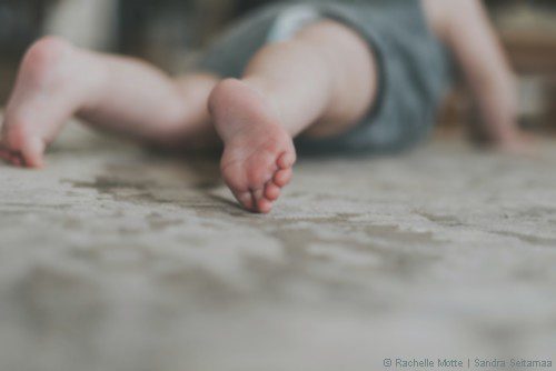 bébé au sol à plat ventre sur un tapis