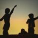 enfants s'amusent dans le soleil couchant