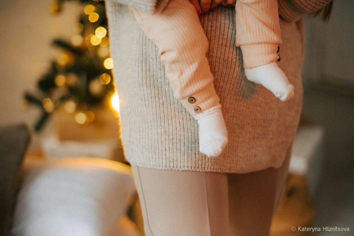 gros plan sur les jambes de bébé porté par sa maman