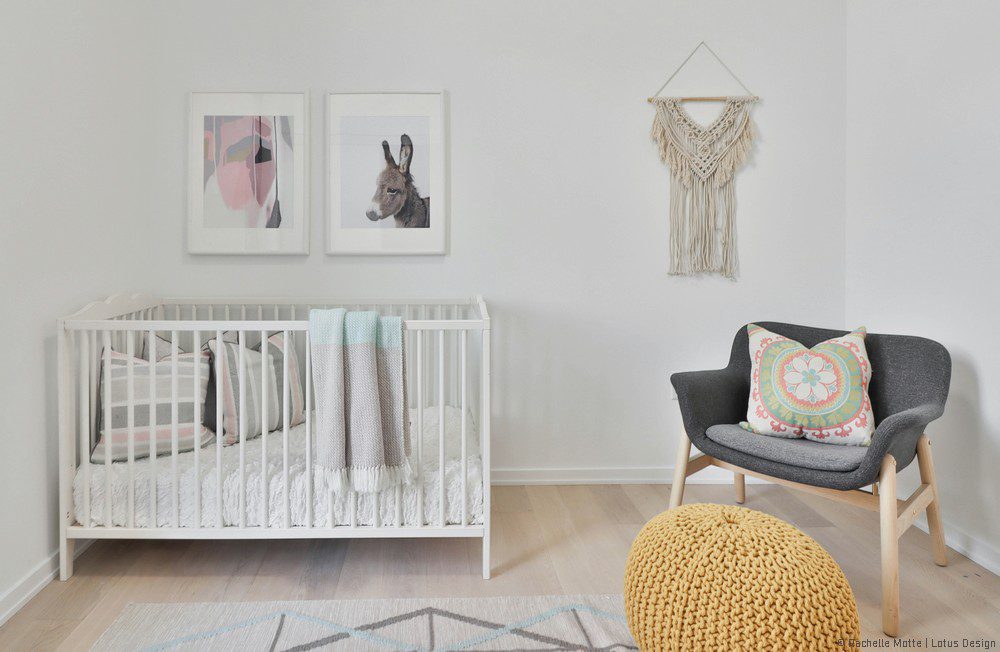 décor de chambre bébé épuré : lit à barreaux, siège, tableaux