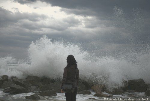femme devant vagues sur rochers