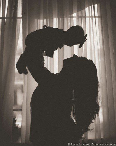 maman lève son bébé au dessus d'elle