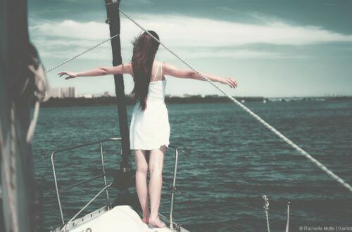 femme sur la proue d'un bateau, les bras en croix