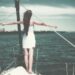 femme sur la proue d'un bateau, les bras en croix