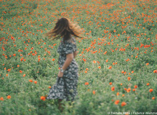 femme virevolte dans champ de coquelicots