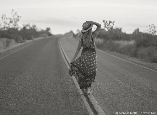 une femme se tient au milieu d'une route