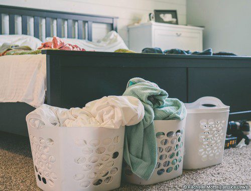 paniers de linge pleins au pied d'un lit