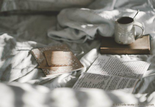 tasse de café, livres et cahiers dans un lit