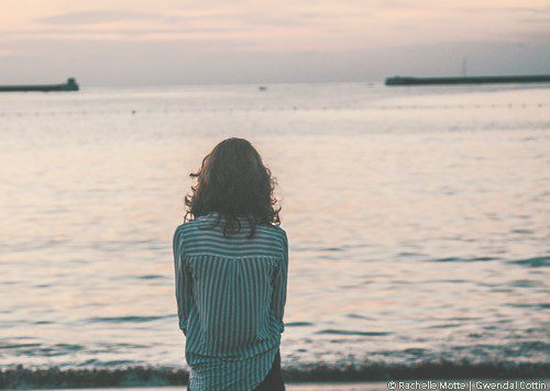 une femme devant la mer regarde l'horizon