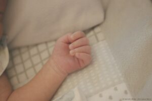 bras bébé étendu dans un lit